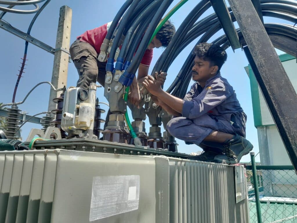 Technicians working on a transformer installation